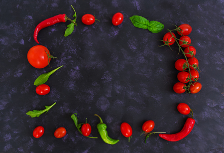 Fresh ripe cherry tomatoes and pepper on a dark background. Top viewの写真素材
