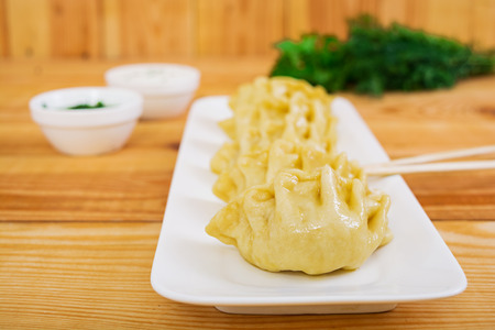 Delicious manti dumplings on wooden backgroundの写真素材