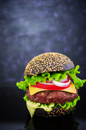 Handmade burger on dark background. Delicious black burgerの写真素材