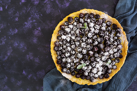 Delicious tart with blackberries on dark background. Top viewの写真素材