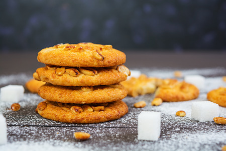 Cookies with peanuts on dark wooden background