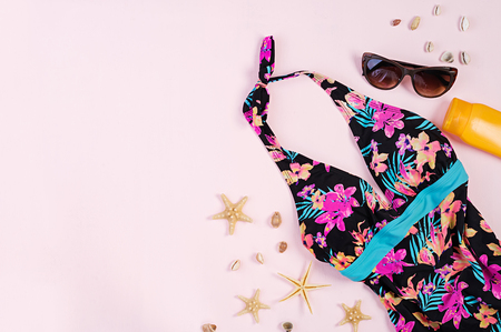 Swimsuit with different seashells and starfish on pink background. Top viewの写真素材