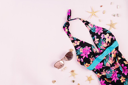 Swimsuit with different seashells and starfish on pink background. Top viewの写真素材