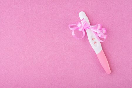 Positive pregnancy test isolated on pink backgroundの写真素材