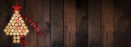 Christmas tree made of wine corks on wooden background. Mockup postcard with Christmas tree and copy space for text. Top view. Banner.の写真素材