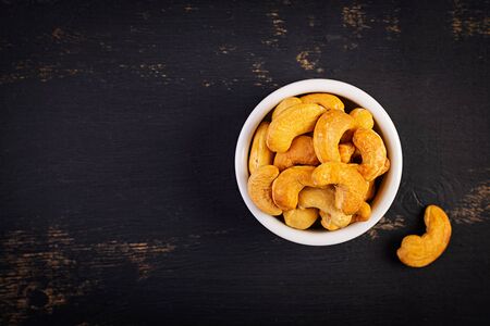 Cashews on dark wooden background. A handful of nuts.の写真素材