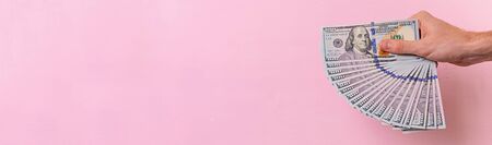 Business concept. Hand with money isolated on pink background.