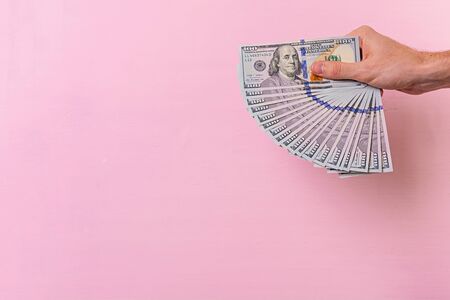 Business concept. Hand with money isolated on pink background.の写真素材