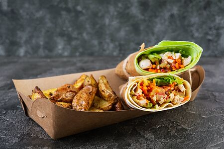 Delicious shawarma sandwich with chicken and potato on wooden backgroundの写真素材