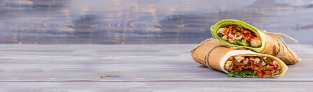 Delicious shawarma sandwich with chicken on wooden backgroundの写真素材