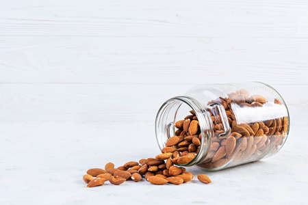 Almonds nuts in a jar. Set of nuts isolated on white backgroundの写真素材