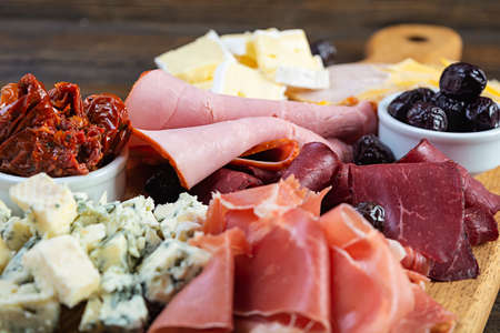 Italian antipasto. Antipasti board with ham, salsami, prosciutto, parmesan, blue cheese and olives.の写真素材
