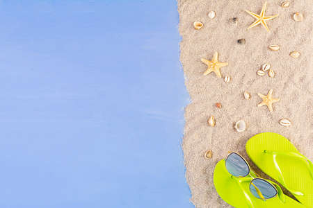 Summer background. Sea sand with seashells, starfish and sunglasses. Summer vacation concept
