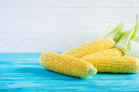 Fresh juicy corn isolated on wooden background. Grain crops concept