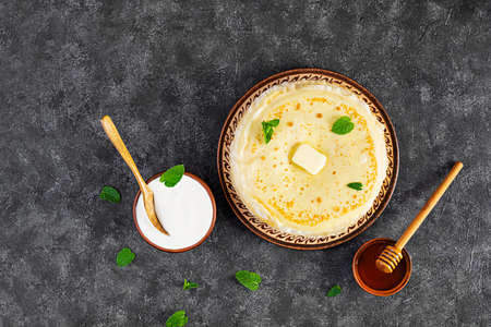 Delicious crepes with honey and sour cream on wooden backgroundの写真素材