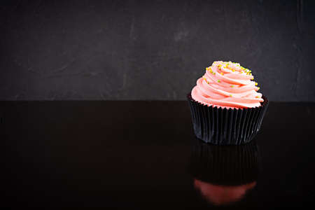 Tasty colorful cupcakes isolated on dark background. Delicious cupcake