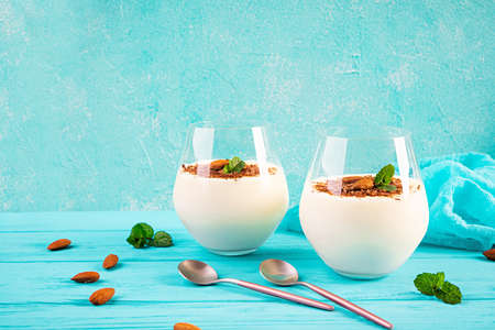 Sweet milk pudding with almonds and chocolate chips on blue backgroundの写真素材