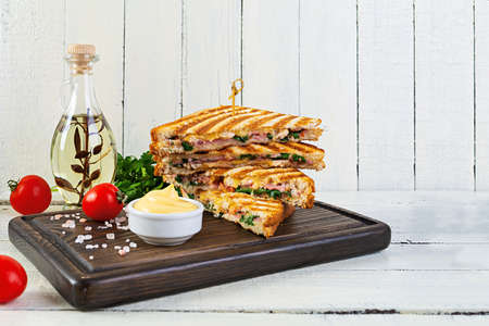 Club sandwich with ham, cheese, tomato, salad and chipsの写真素材