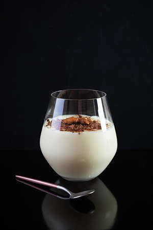 Sweet milk pudding with almonds and chocolate chips isolated on dark backgroundの写真素材
