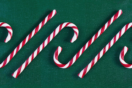 Christmas striped candy cane isolated on green background. Candy cane pattern. Top view