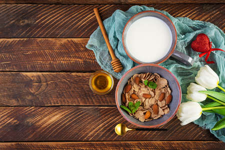 Spelt flakes with milk on breakfast. Light breakfast on Valentine's day with tulips and heart