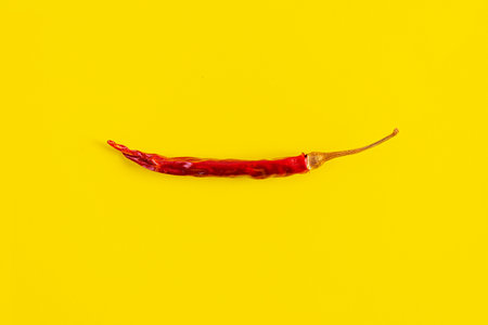 Dried red chili pepper on yellow background. Texture of isolated chili peppersの写真素材