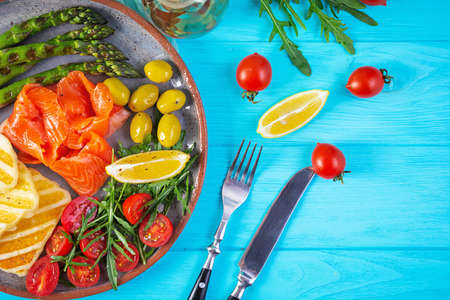 Salad with asparagus, grilled halloumi cheese, salmon fillet, tomatoes, arugula and green olives. Top viewの写真素材
