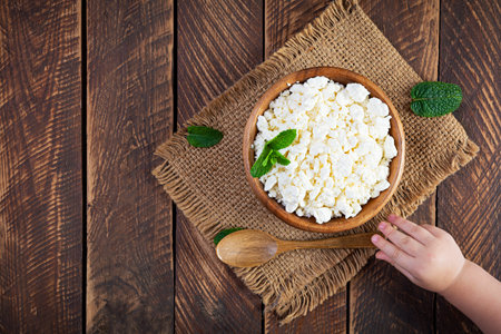 Bowl of cottage cheese on wooden background. Fresh homemade cottage cheese. Top viewの写真素材