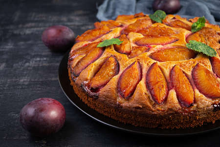 Delicious plum cake on wooden background. Homemade plum pieの写真素材