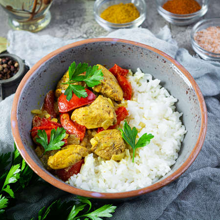Spicy chicken curry with rice. Curry sauce with chicken and rice on gray backgroundの写真素材