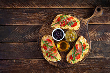 Grilled bruschetta with chicken rillettes, jamon and herbs. Delicious toast with chicken pate and different appetizersの写真素材