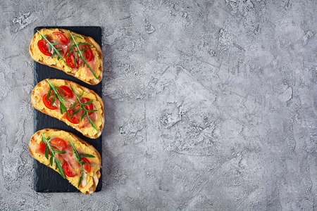 Grilled bruschetta with chicken rillettes, jamon and herbs. Delicious toast with chicken pate and different appetizersの写真素材