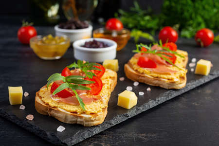 Grilled bruschetta with chicken rillettes, jamon and herbs. Delicious toast with chicken pate and different appetizersの写真素材