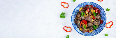 Delicious fried chicken liver with pepper, apples and herbs on light wooden background. Top view