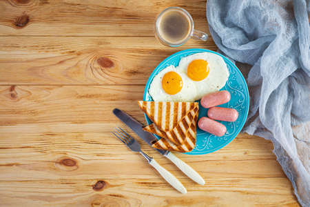 Tasty breakfast with eggs, sausages, toasts and cup of coffee. American breakfast. Top viewの写真素材