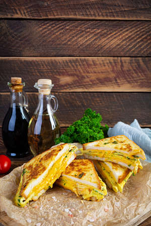 Roasted French toast with ham, egg, herbs and cheese cheddar. Delicious grilled breakfast sandwichの写真素材