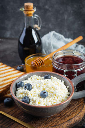 Delicious cottage cheese with blueberry, honey, strawberry jam and toast. Healthy breakfastの写真素材
