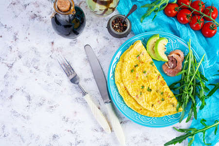 Fried omelette with ham, onion and herbs. Breakfast with scrambled eggsの写真素材