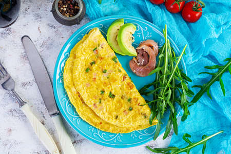Fried omelette with ham, onion and herbs. Breakfast with scrambled eggsの写真素材