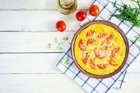 Omelette with tomatoes, herbs and grated cheese. Easy breakfast