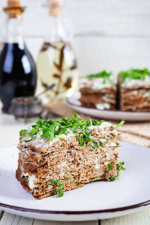 Liver cake on wooden background. Sliced layered liver cake with mayonnaiseの写真素材