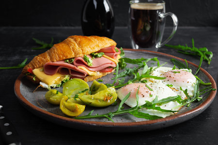 Breakfast with fried eggs and croissant sandwith with ham, cheese and salad. Delicious morning...