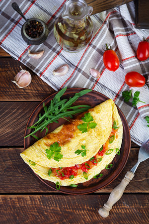 Omelette with fried onions and tomatoes. Fried eggs with herbs