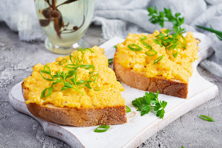 Scrambled eggs with herbs and toasts. Delicious breakfast with eggs and herbsの写真素材