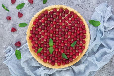 Delicious tart with custard and raspberries. Raspberry cake decorated with mint leaves