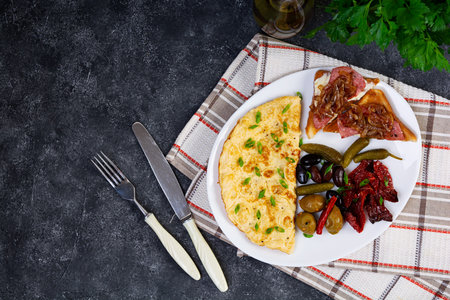 Omelette with toast, olives and sun-dried tomatoes. Tasty omelet breakfast