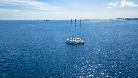 Aerial view of yacht sailing near beautiful Islands. Beautiful clouds in the background. Luxury...