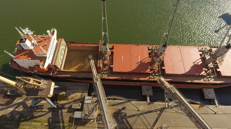 Aerial view of big grain elevators on the sea. Loading of grain on a ship. Port. Cargo ship