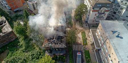 Fire is burning in a residential area. A fire truck is parked on the street. The fire is visible...