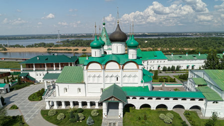 Large green building with a white roof and a large white dome. The building is surrounded by trees...
